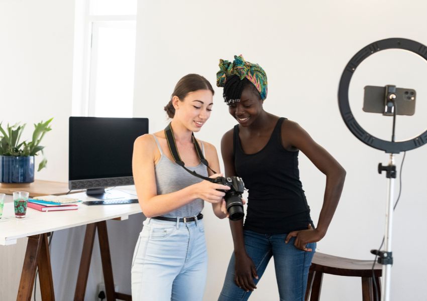 A photographer stands in front of a home desk, showing a landlord marketing photos taken of a Pensacola rental property.